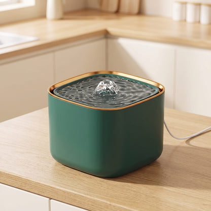 Fontaine à eau pour chat verte 3 L posée sur un plan de travail en chêne dans une cuisine claire