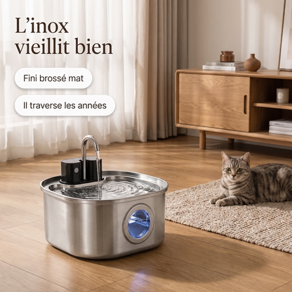 Fontaine à eau en inox posée au sol dans un salon en tons crème et chêne