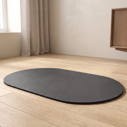 Tapis imperméable ovale anthracite pour fontaine à eau chat, posé sur un parquet clair