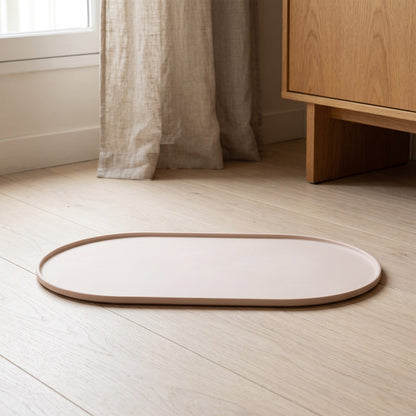 Tapis en silicone beige à rebord relevé pour fontaine à eau chat, posé sur un parquet clair