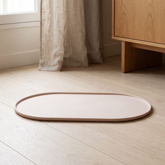Tapis en silicone beige à rebord relevé pour fontaine à eau chat, posé sur un parquet clair