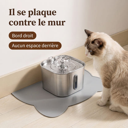 Fontaine à eau en inox posée sur le tapis gris plaqué contre le mur